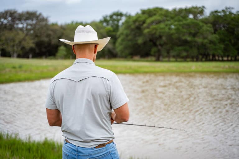 man fishes at recreation pond in rural county